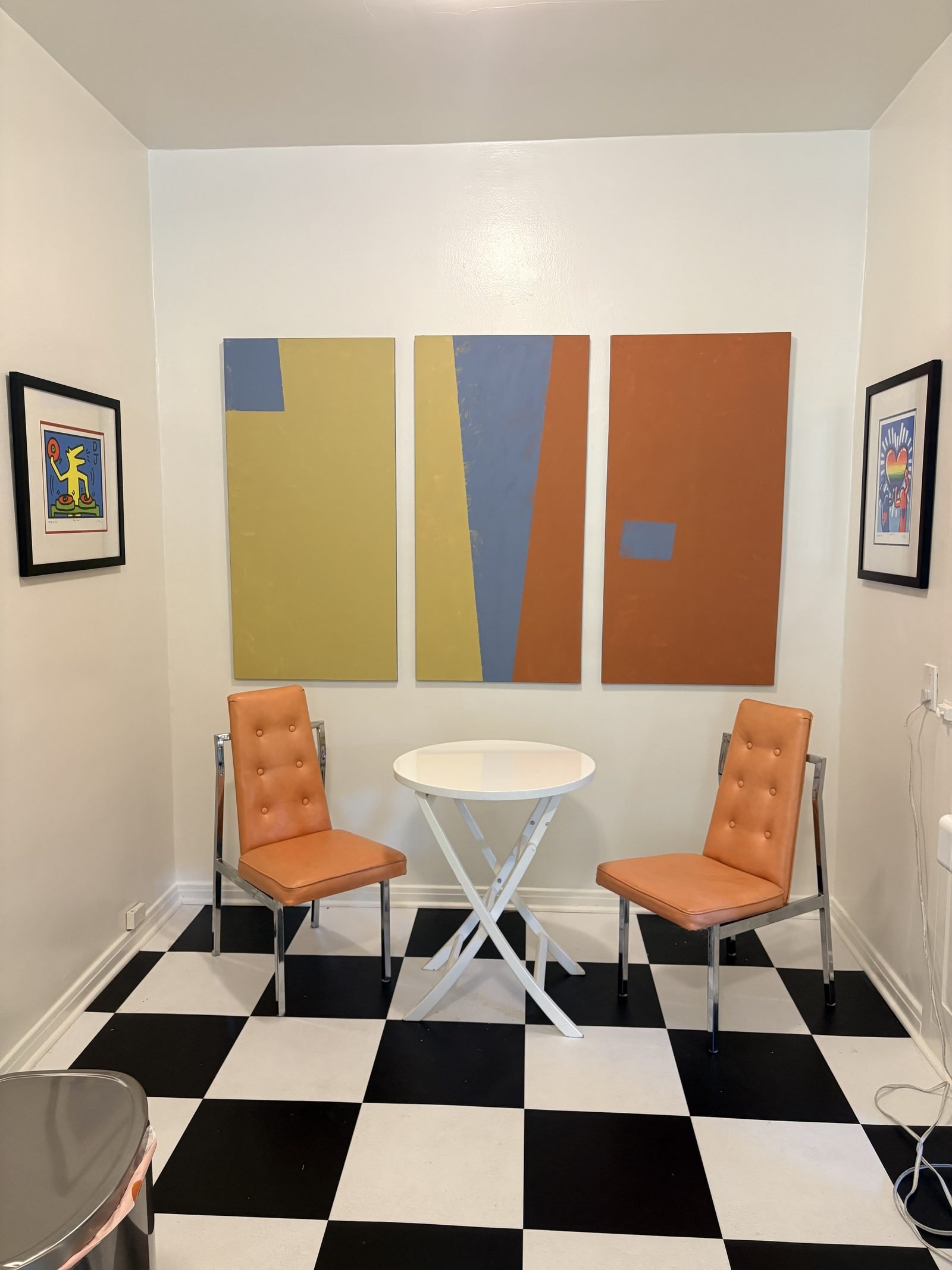 Three abstract art panels mounted in a row in dining nook