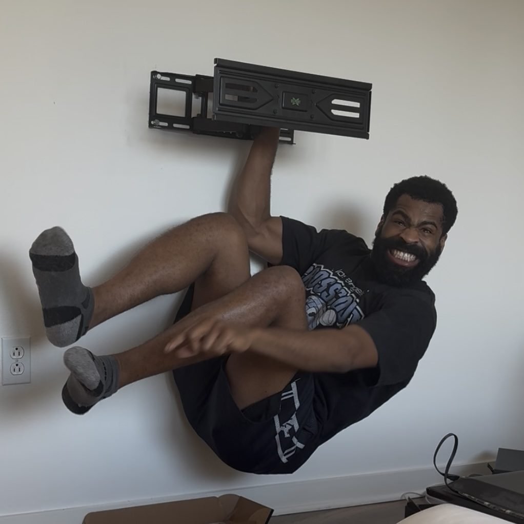 Ike testing the strength of a mounted TV bracket