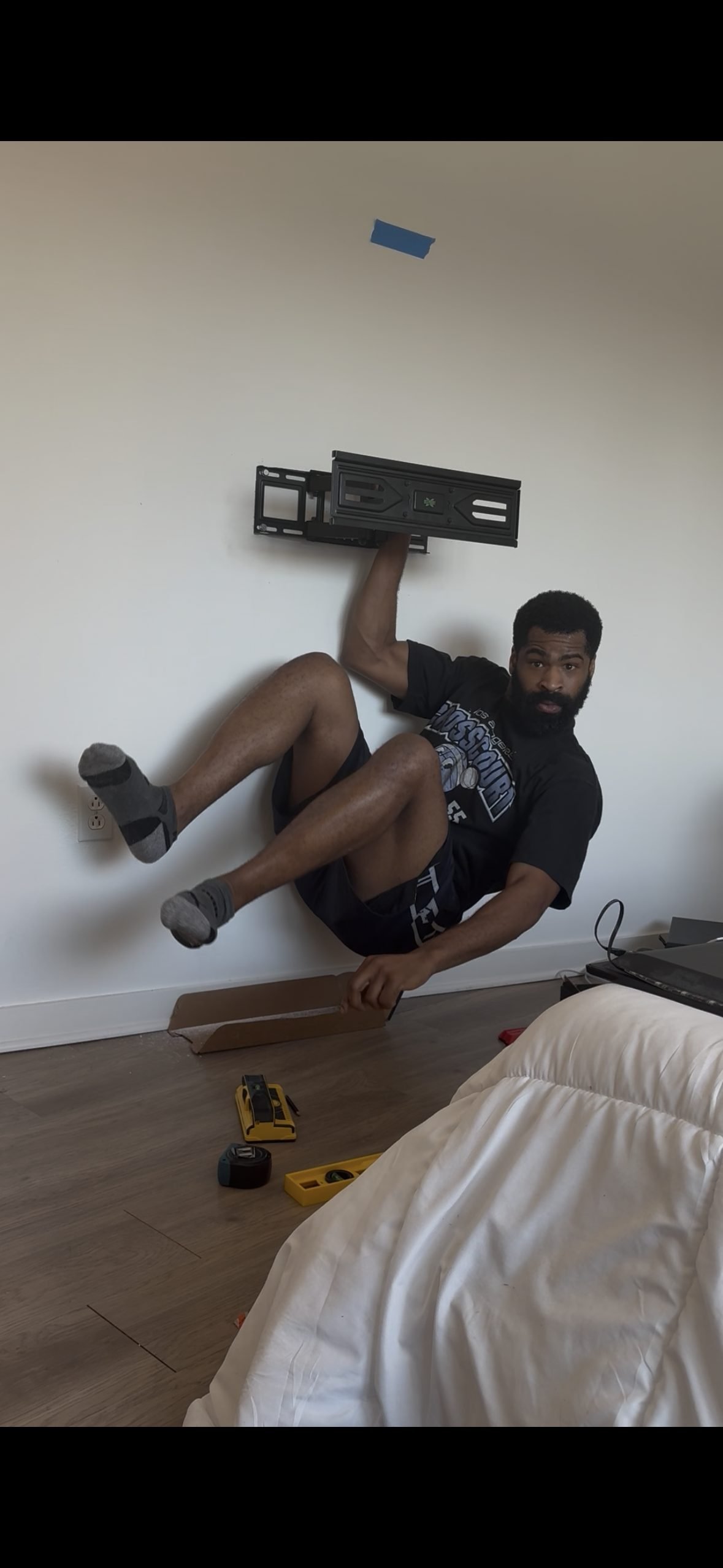 Ike hanging from a TV wall mount in a Los Angeles bedroom install