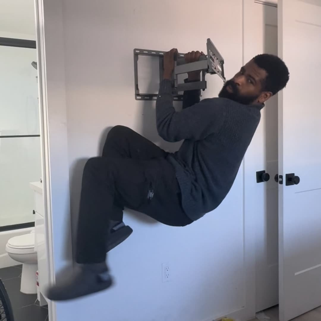 Ike installing TV bracket on wall